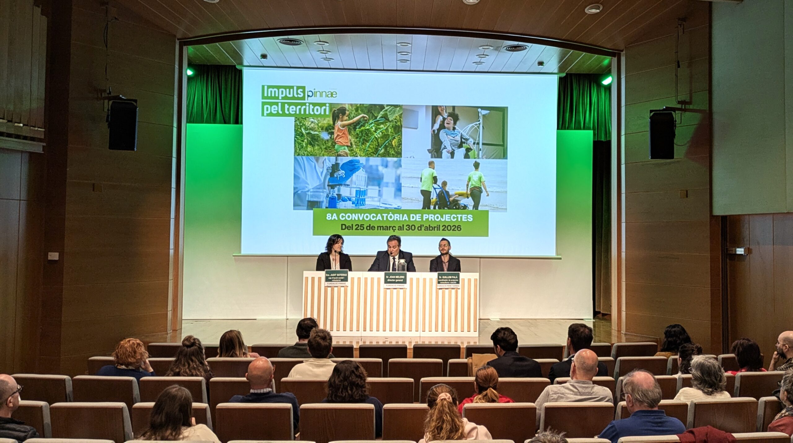 auditori del fòrum, dos homes i una dona amb taula presidencial parlant sobre la nova edició de la convocatòria d'impuls pel territori